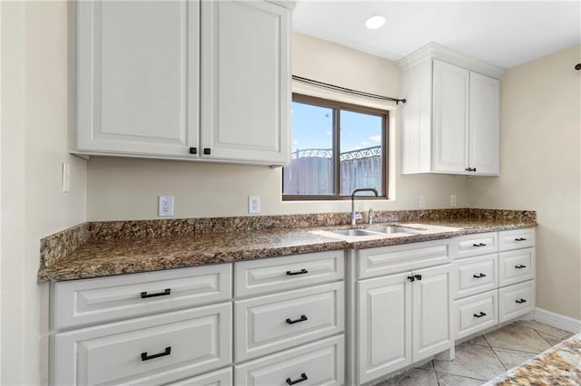 2601 Moreno Sr, Edinburg, TX 78541 - kitchen with a sink, light marble finish flooring, white cabinets, baseboards, and recessed lighting