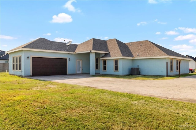 2601 Moreno Sr, Edinburg, TX 78541 - rear view of house featuring driveway, central air condition unit, an attached garage, a lawn, and stucco siding