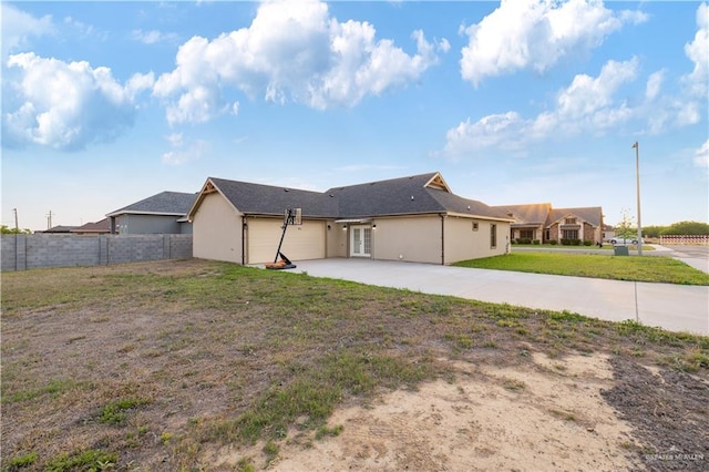 612 Spruce St, Rio Grande City, TX 78582 - rear view of house featuring an attached garage, concrete driveway, a patio, french doors, and stucco siding