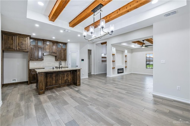 612 Spruce St, Rio Grande City, TX 78582 - kitchen featuring beamed ceiling, dark brown cabinetry, ceiling fan, tasteful backsplash, and light wood-style floors
