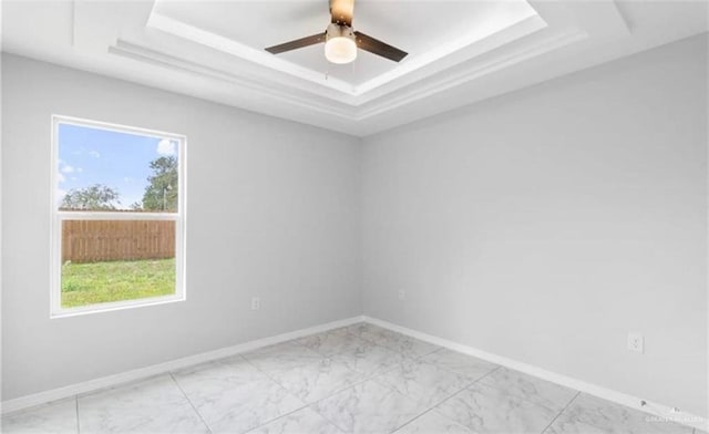 unfurnished room featuring a raised ceiling and ceiling fan