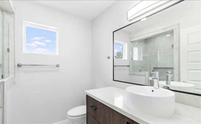 bathroom with walk in shower, a wealth of natural light, vanity, and toilet