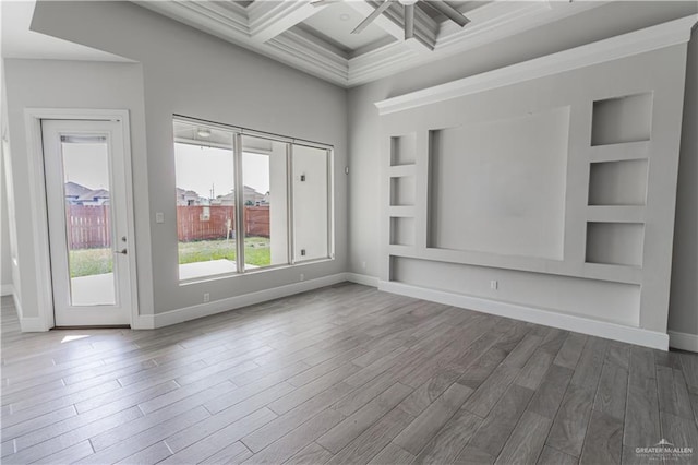 unfurnished living room with ceiling fan, coffered ceiling, wood-type flooring, built in shelves, and beamed ceiling