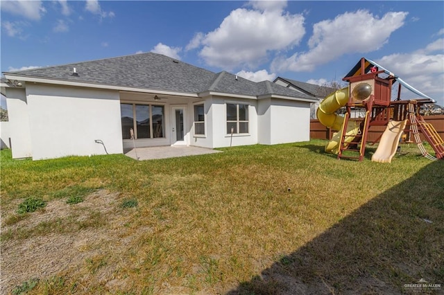 back of property featuring a lawn, a patio, and a playground