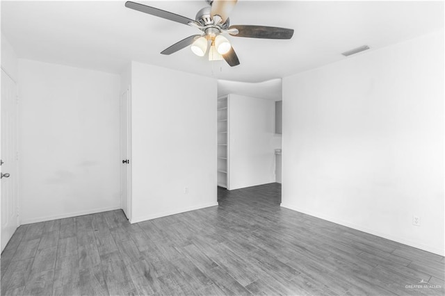 unfurnished room with wood finished floors, visible vents, baseboards, and ceiling fan