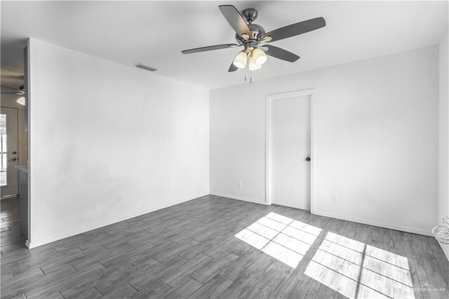 spare room with ceiling fan, wood finished floors, and visible vents