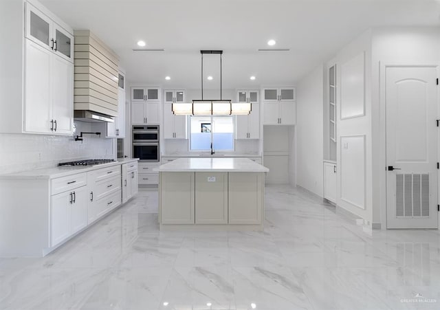 kitchen featuring marble finish floor, visible vents, decorative backsplash, appliances with stainless steel finishes, and a kitchen island