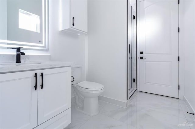 bathroom featuring toilet, marble finish floor, vanity, and baseboards