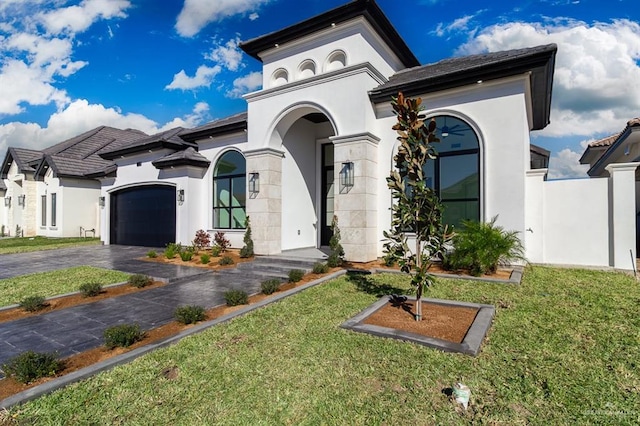 view of front of house featuring a front yard, driveway, an attached garage, and stucco siding