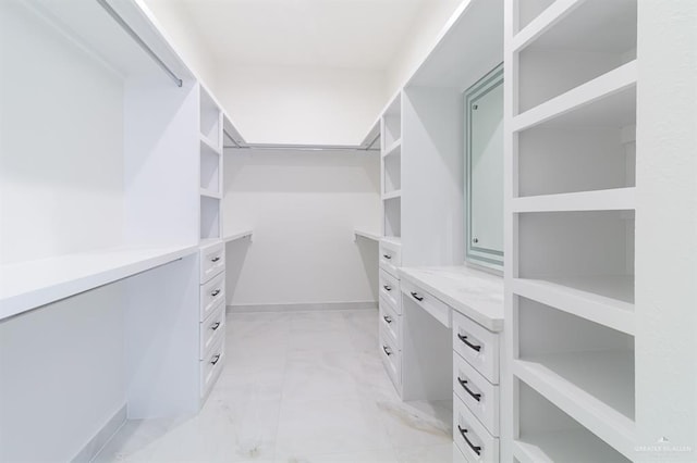 walk in closet with marble finish floor