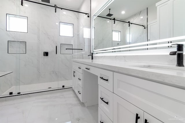 full bath with marble finish floor, a sink, a marble finish shower, and double vanity