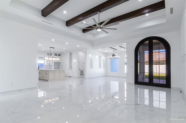 interior space with marble finish floor, baseboards, arched walkways, and beam ceiling