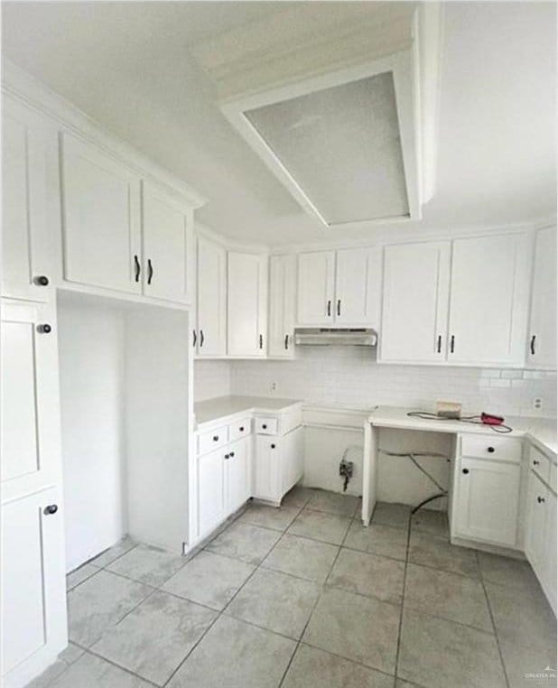 kitchen featuring decorative backsplash, white cabinetry, and light tile patterned flooring