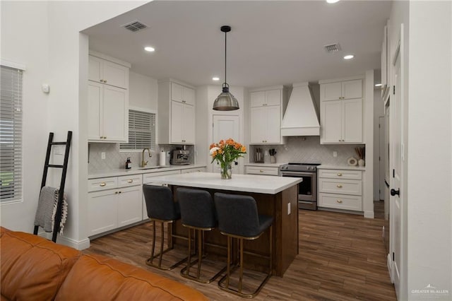 3101 E Iverson Ave, Edinburg, TX 78542 - kitchen featuring stainless steel range with electric stovetop, custom range hood, light countertops, a center island, and recessed lighting