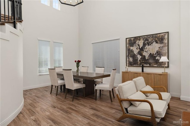 3101 E Iverson Ave, Edinburg, TX 78542 - dining area featuring a towering ceiling, baseboards, wood finished floors, and a chandelier