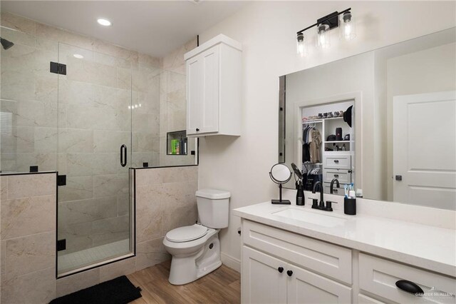 3101 E Iverson Ave, Edinburg, TX 78542 - bathroom featuring wood finished floors, toilet, a shower stall, vanity, and recessed lighting