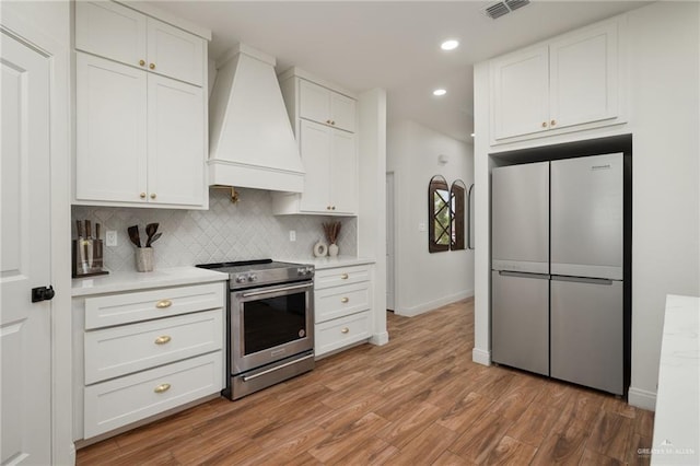 3101 E Iverson Ave, Edinburg, TX 78542 - kitchen with stainless steel appliances, custom exhaust hood, light countertops, recessed lighting, and white cabinetry