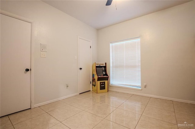 tiled spare room featuring ceiling fan and plenty of natural light