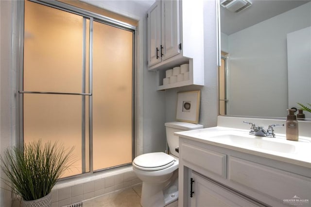 bathroom with tile patterned floors, vanity, toilet, and an enclosed shower