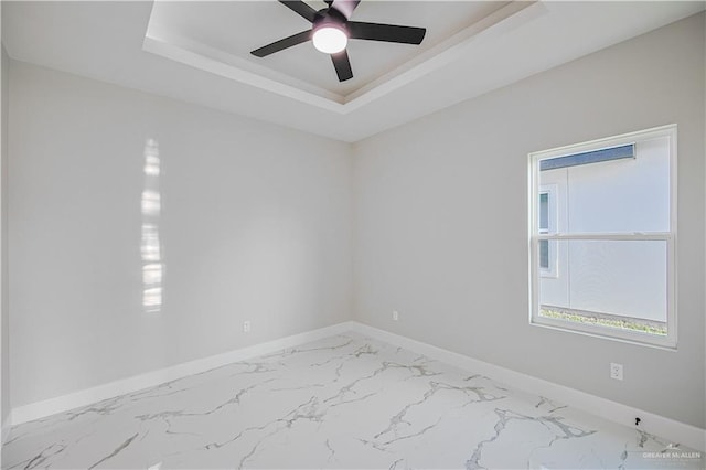 8038 N 51st St, Mcallen, TX 78504 - unfurnished room featuring a tray ceiling, marble look tile flooring, and a ceiling fan