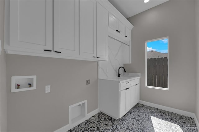 washroom featuring cabinets, sink, hookup for a washing machine, hookup for an electric dryer, and light tile patterned flooring