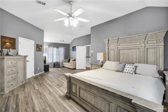 bedroom featuring ceiling fan, wood-type flooring, and vaulted ceiling