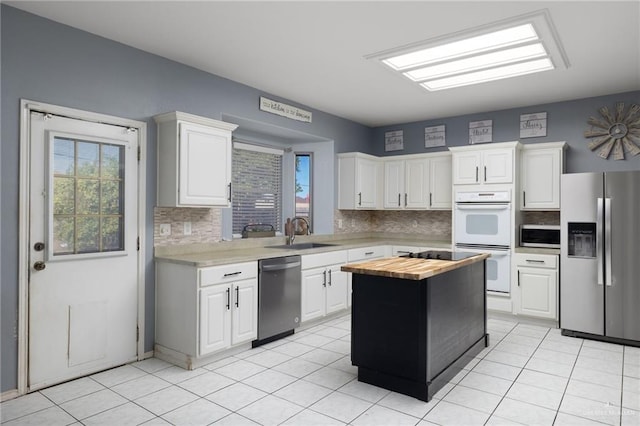 kitchen with white cabinets, appliances with stainless steel finishes, and light tile patterned floors