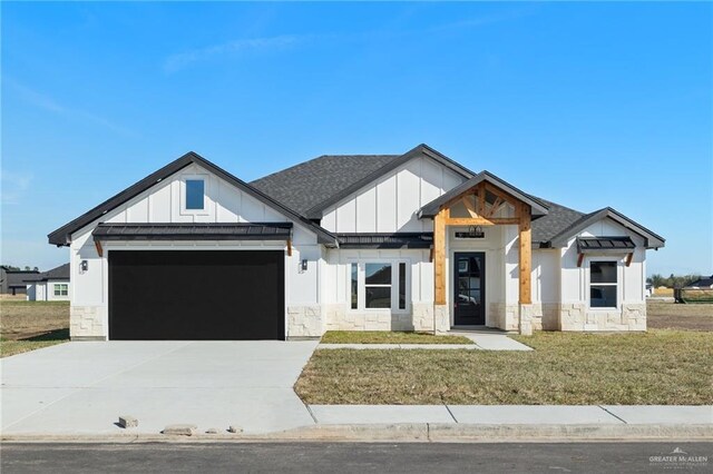 modern farmhouse style home featuring a garage, driveway, roof with shingles, a front lawn, and board and batten siding