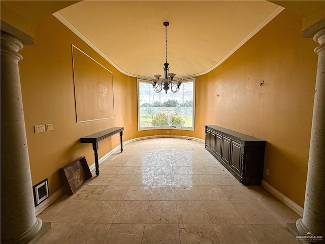 unfurnished dining area featuring ornate columns, crown molding, and a notable chandelier