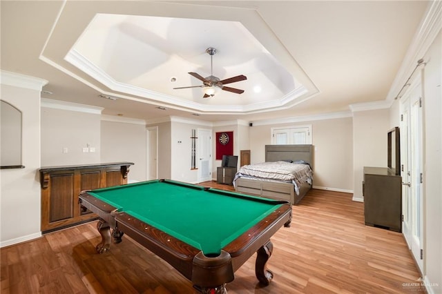 rec room featuring ornamental molding, ceiling fan, light hardwood / wood-style floors, and a tray ceiling