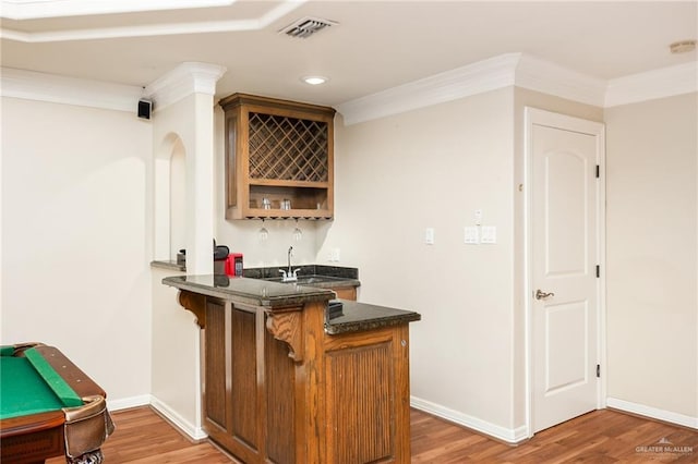 bar with crown molding, sink, and light hardwood / wood-style floors