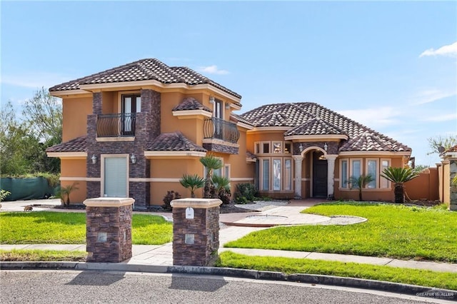 mediterranean / spanish home featuring a front lawn and a balcony