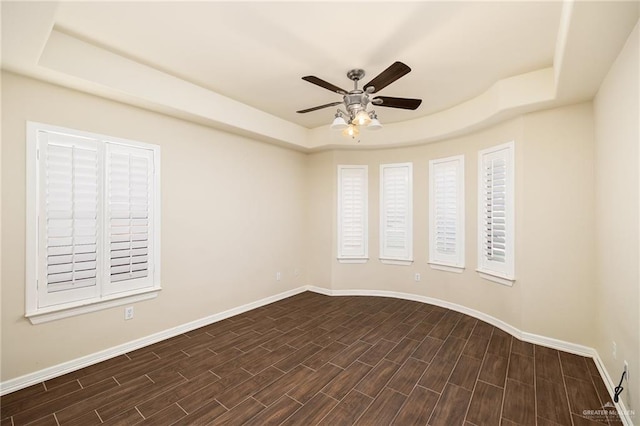 spare room featuring a raised ceiling and ceiling fan