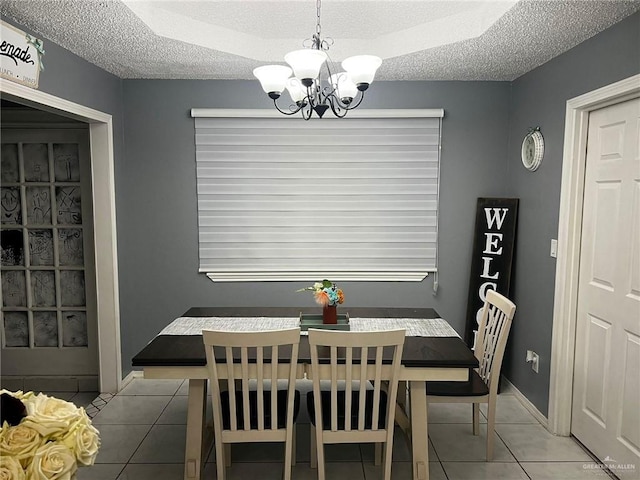 dining room featuring light tile patterned flooring, a chandelier, and a textured ceiling