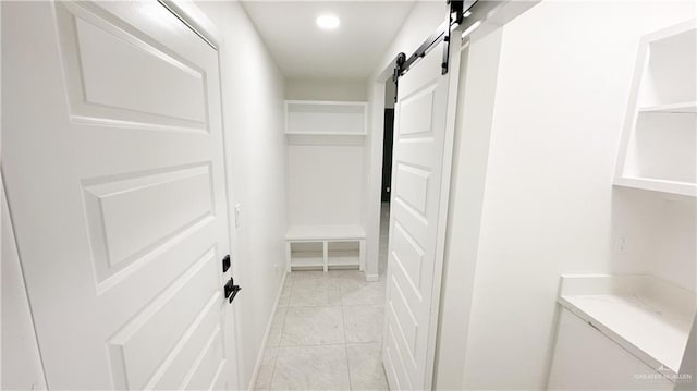 spacious closet with light tile patterned floors and a barn door