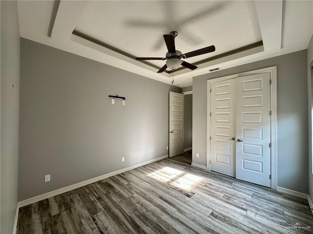 5016 Kendlewood Ave, Mcallen, TX 78501 - unfurnished bedroom with a tray ceiling, wood finished floors, and baseboards