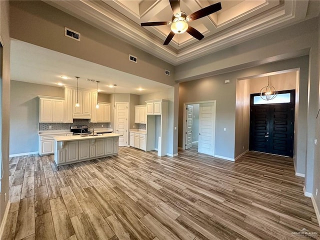 5016 Kendlewood Ave, Mcallen, TX 78501 - kitchen featuring a high ceiling, coffered ceiling, baseboards, light countertops, and light wood-style flooring