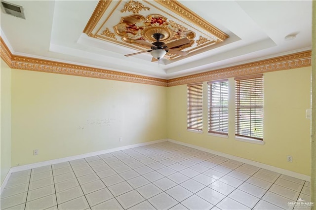 spare room with a raised ceiling, baseboards, visible vents, a ceiling fan, and light tile patterned floors