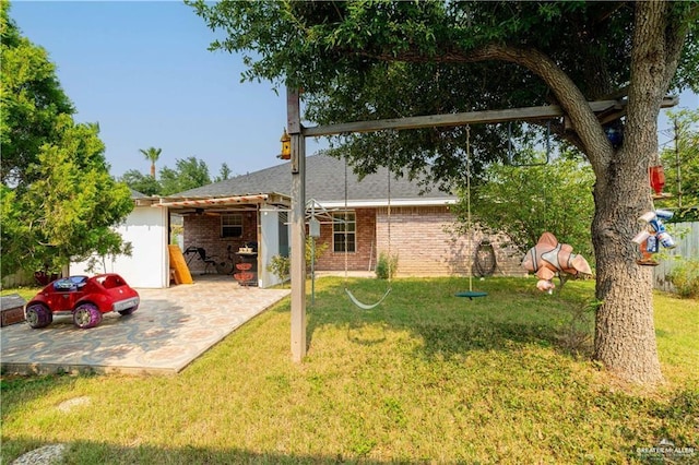 rear view of house featuring a lawn, brick siding, and a patio