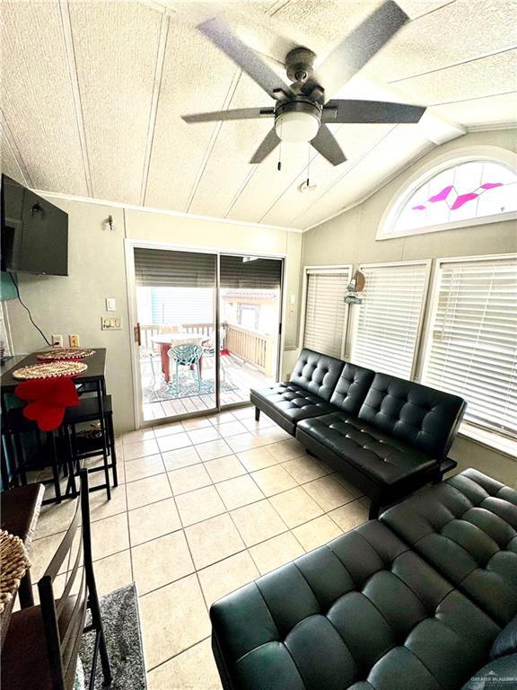 379 Sand Dollar Dr, Port Isabel, TX 78578 - living room featuring light tile patterned flooring, lofted ceiling, and ceiling fan