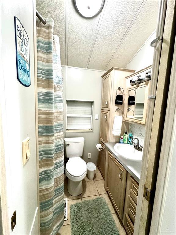 379 Sand Dollar Dr, Port Isabel, TX 78578 - bathroom featuring a textured ceiling, tile patterned floors, and vanity