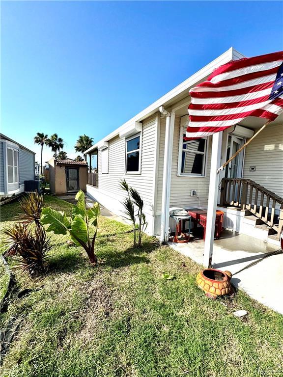 379 Sand Dollar Dr, Port Isabel, TX 78578 - view of home's exterior featuring a storage unit and a lawn