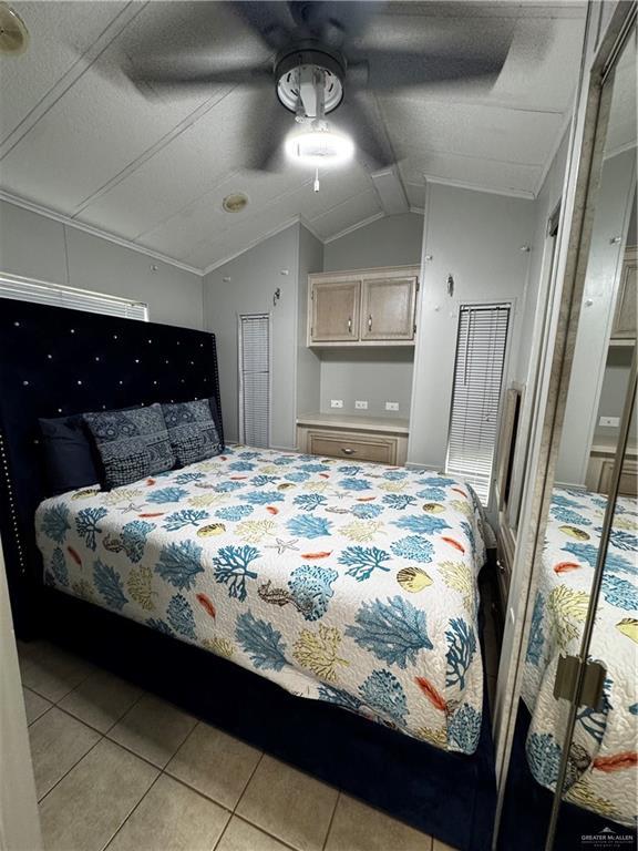 379 Sand Dollar Dr, Port Isabel, TX 78578 - bedroom with vaulted ceiling, light tile patterned floors, and a ceiling fan