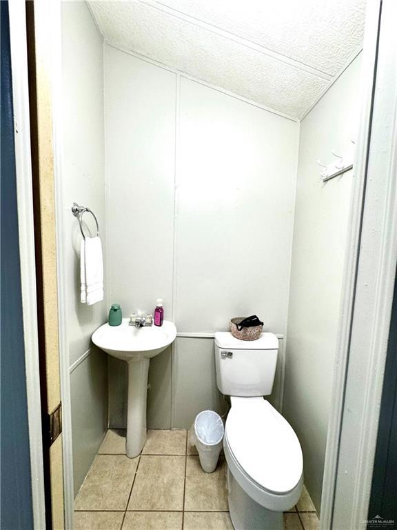 379 Sand Dollar Dr, Port Isabel, TX 78578 - half bathroom with tile patterned floors and a textured ceiling