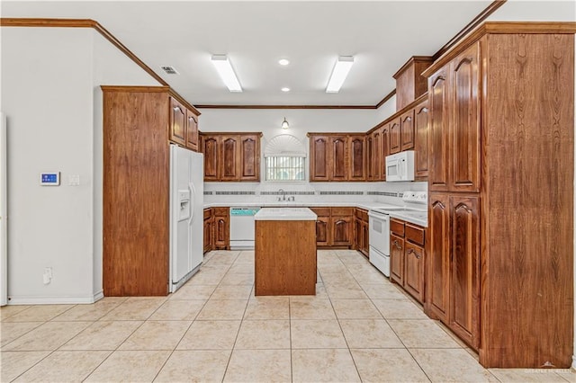 kitchen featuring sink, a kitchen island, crown molding, white appliances, and light tile patterned floors