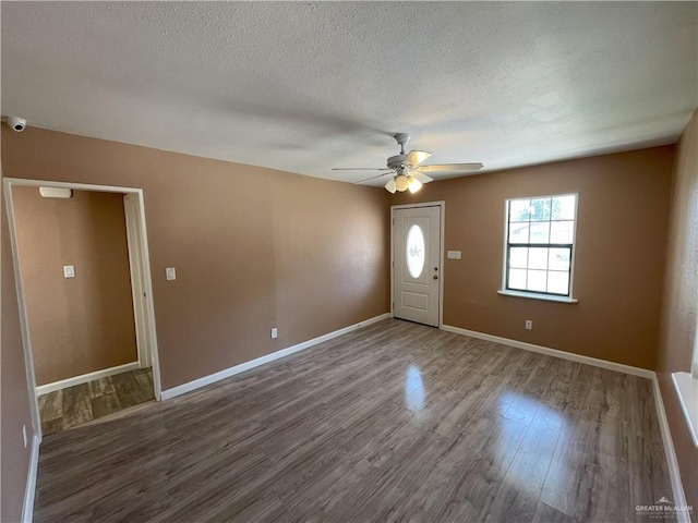 foyer featuring a ceiling fan, a textured ceiling, wood finished floors, and baseboards