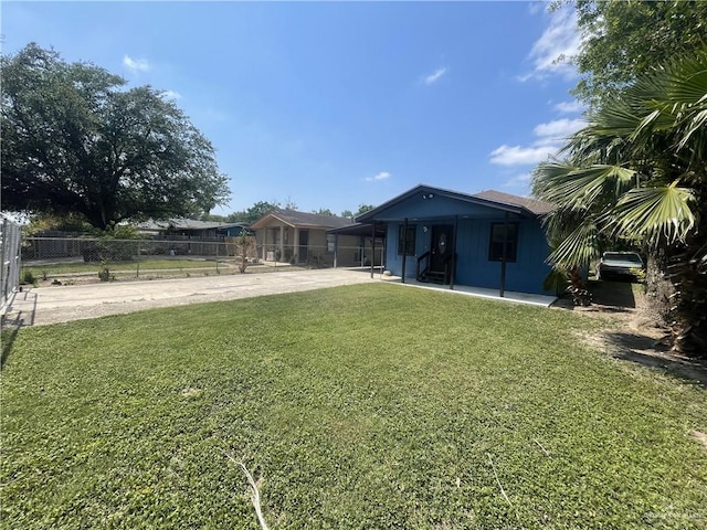 view of yard with fence and concrete driveway