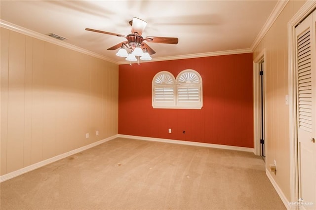 spare room featuring crown molding, light carpet, and ceiling fan