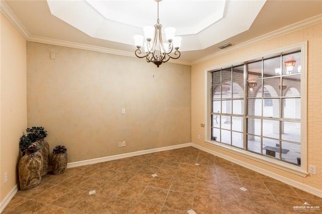 tiled empty room with an inviting chandelier, ornamental molding, and a tray ceiling