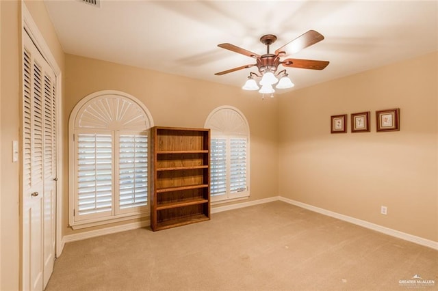 unfurnished bedroom with ceiling fan, carpet flooring, and a closet